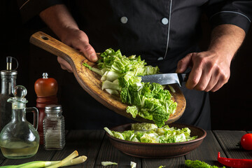 Professional chef makes a fresh napa cabbage salad. Preparation for slicing in the kitchen. Vegetable diet idea