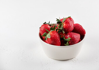 strawberries in a bowl on white background