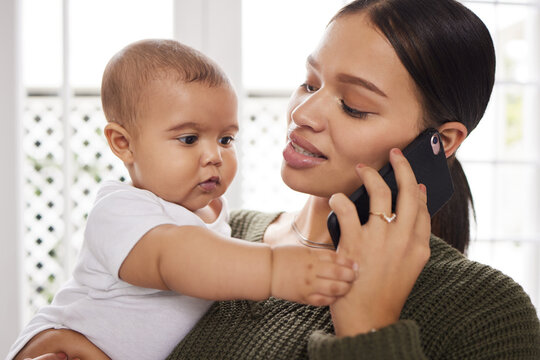 A baby boy may leave smudges in the house and also on your heart. Shot of a young woman using a smartphone while carrying her baby at home.