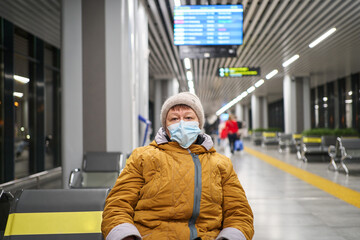 senior woman in a protective mask at an empty airport. travel senior citizen. pandemic