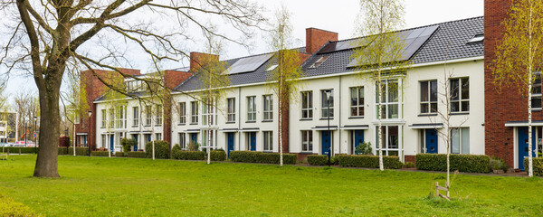 Row of modern newly build family houses along canal in Kortenoord in Wageningen, Gelderland in The...