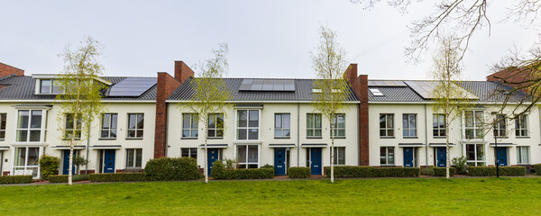 Row of modern newly build family houses along canal in Kortenoord in Wageningen, Gelderland in The Netherlands
