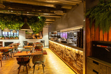Interior of cozy restaurant in the modern style with open kitchen