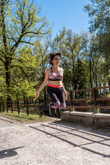 beautiful middle aged woman jumping rope outdoors