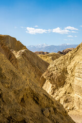 Snow Capped Mountain Stands High Above A Passageway Through Golden Canyon