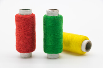 yellow, green and red color yarn or spool thread over on white background