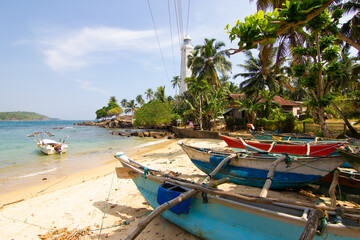 Fisherman boats and beautiful white lighthouse Dondra Head, Sri Lanka