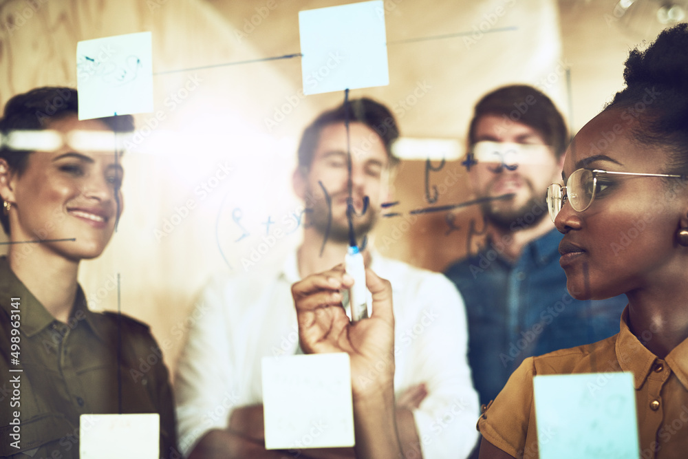 Poster finding solutions as a team. shot of a group of businesspeople brainstorming with notes on a glass w