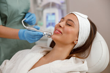 Potrait of female client getting aesthetic face treatment in beauty salon. Rejuvenation, hydration
