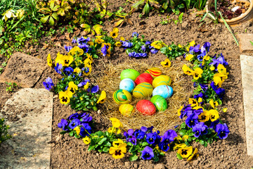Nest mit Ostereiern und Stiefmütterchen
