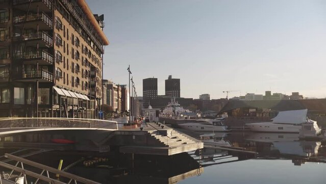 Silent docks at Oslos high-end shopping and dining district Aker brygge. With the capitol town hall in the background