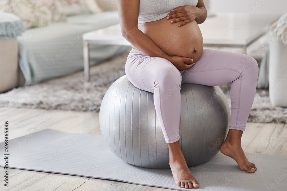 Poster Every mom-to-be should get a stability ball. Cropped shot of a pregnant woman sitting on a stability ball at home.