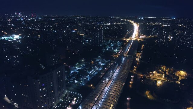 Aerial drone top notch fly over night highway with moving cars, lights and trucks, buildings and atmosphere of modern cosmopolitan city in Varsovia, Poland