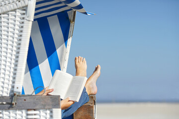 reading a book in beach chair in summer vacation