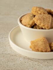 Сottage layer cookies with sugar and cinnamon in the white ceramic bowl on the white ceramic plate