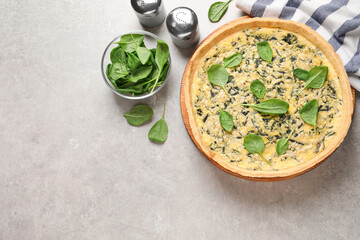 Delicious homemade spinach pie on light grey table, flat lay. Space for text