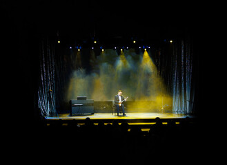 Smoke and light on the stage. Male musicians balalaika player perform a concert on stage