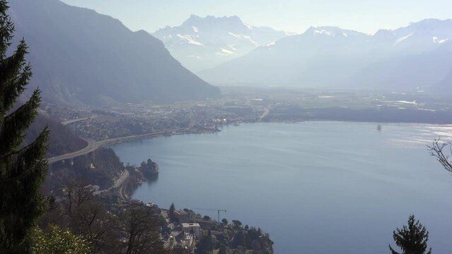 Snow capped mountains of the Swiss alps with Chillon Castle and Lake Geneva. Switzerland