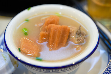 A bowl of delicious and sweet lotus root pork ribs soup close-up
