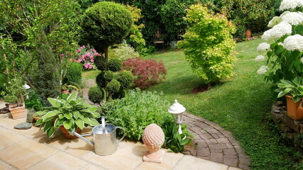 Garten mit Fussweg und diversen grünen und blühenden Pflanzen © turtles2