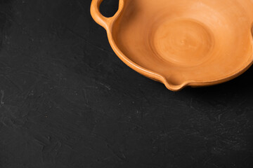 Clay pots for cooking. Pots of clay of a light colour. Baking dishes on a dark background. A clay pot with a lid for roasting. Vintage kitchen utensils for cooking.