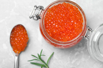 Delicious red caviar and rosemary on light grey table, flat lay