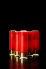 Shotgun shells on a black reflective surface. Ammunition for 12 gauge smoothbore weapons. Hunting ammunition. Dark back.