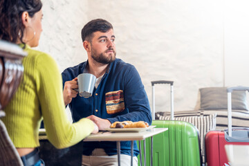 Young tourist couple talking and having breakfast in a hotel