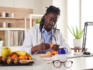 young nutritionist take a break in office and eat a tangerine