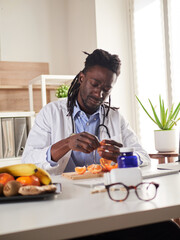 young nutritionist take a break in office and eat a tangerine