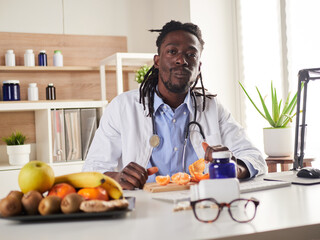 young nutritionist take a break in office and eat a tangerine