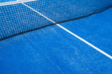 partial view of the netting of a blue paddle tennis court