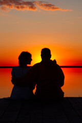Fototapeta na wymiar happy couple at sunset by the sea