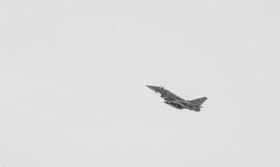 Eurofighter Typhoon military aircraft part of the Italian Air Force flying against blue sky. Military industry. Romania, 2022. - obrazy, fototapety, plakaty