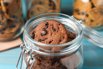 Delicious chocolate chip cookies in glass jar on table, closeup