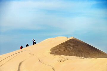 Fototapeta na wymiar Bikers groupin sand desert dunes Qatar