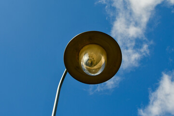 Street light. A large lamp against a cloudy blue sky. Lantern close-up.