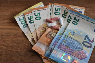 euro banknotes and medicines, pills and capsules