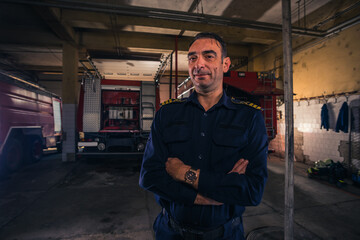 Obraz na płótnie Canvas Portrait of fireman standing inside the fire department