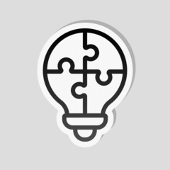 Puzzle lightbulb, team idea, simple icon. Linear sticker, white border and simple shadow on gray background