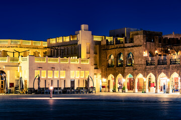 Streets and buildings in the city of Doha, Qatar. Night view of the illuminated houses in the historical center of the city.