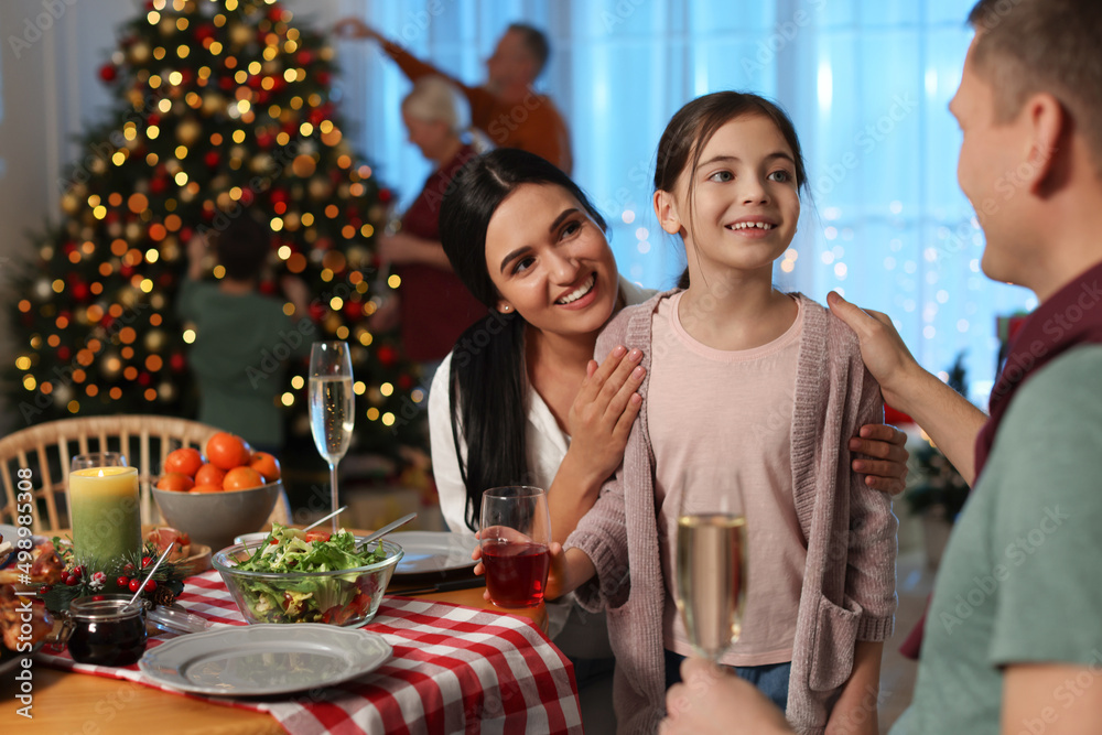 Poster happy family celebrating christmas at home in evening