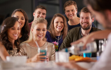 Drinks and a show. Shot of a happy group of friends having drinks at a bar together.