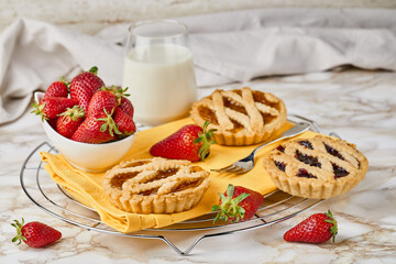 Jam tarts with strawberries and milk