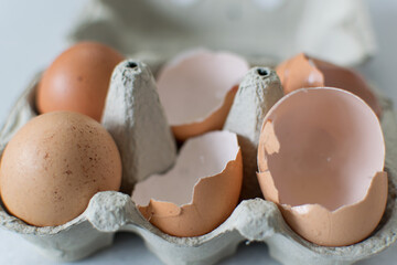 Eggs and eggshell cracked in the same carton container, cooking, food ingredient