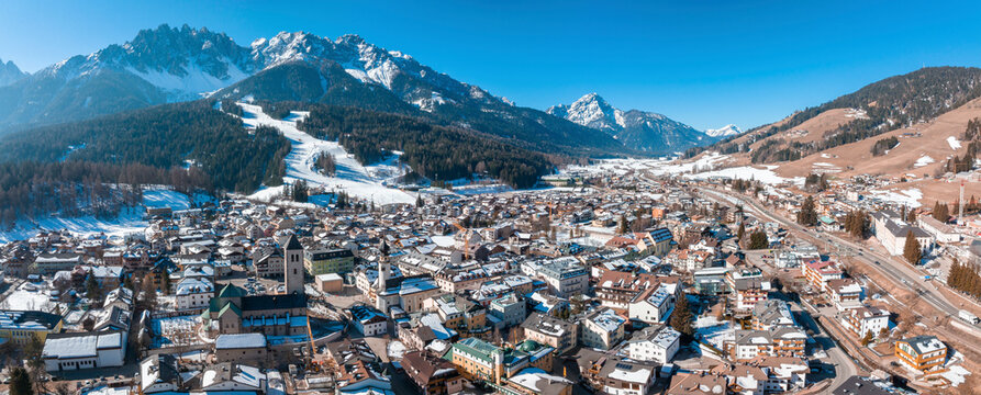 Panoramic view of buildings in town against mountains range on sunny day