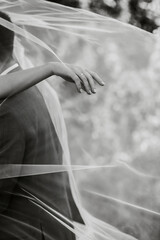 Loving wedding couple in the forest for a walk. The bride has a beautiful long veil and black hair. sunny summer day