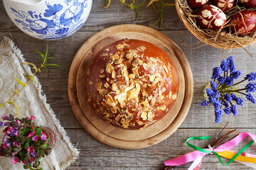 Fototapeta na wymiar Mazanec, traditional Czech sweet Easter pastry, with spring flowers, Easter eggs and whip called pomlazka