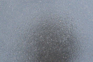 Dark wet asphalt after rain outdoors, top view. Rough texture background