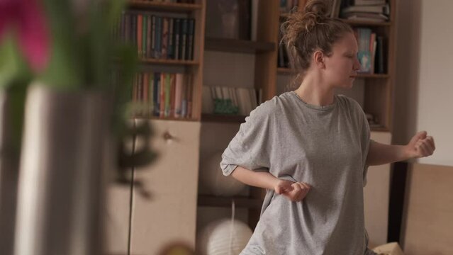 Woman practicing qigong at her cozy apartment